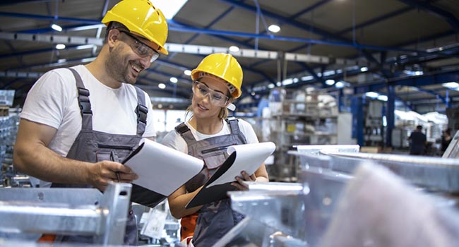 Trabajadores con casco amarillo en fábrica